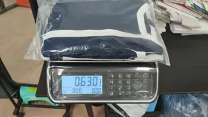 Detail view showing packaged dark blue colorblock dress weighed on electronic scale 0.630kg