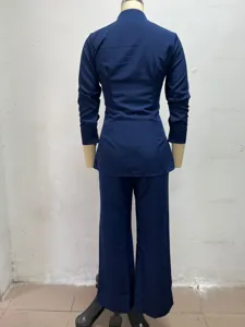 Vista posteriore dell'elegante camicia blu scuro a maniche lunghe e pantaloni ampi.