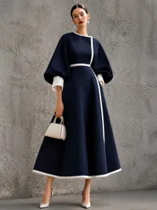 Elegant dark blue midi dress detail, featuring white contrast piping and chic lantern sleeves.