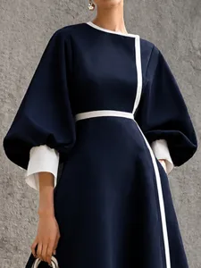 Elegant contrast color midi dress with lantern sleeves and waist cinching design for women.