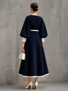 Elegant dark blue contrast midi dress with chic lantern sleeves and stylish white trim accents.