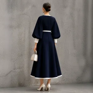 Elegant navy blue midi dress with white contrast trim, chic lantern sleeves and waist-cinching fit.