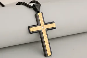 Detailed close-up of a stainless steel two-tone cross pendant featuring a textured center strip.