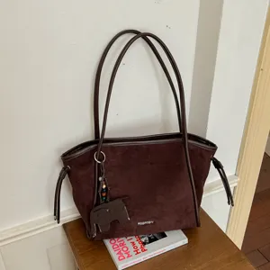Gros plan sur le détail du sac fourre-tout en suédine marron rétro avec jolie texture.
