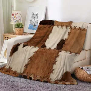 Flannel fleece blanket with cowhide patch print and cross leather laces for cozy home decor.