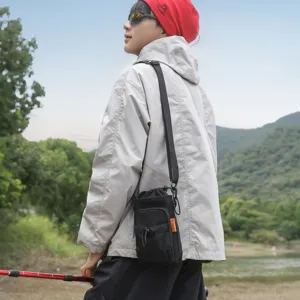 Detailed view of the outdoor crossbody phone bag worn by a model in a scenic nature setting.