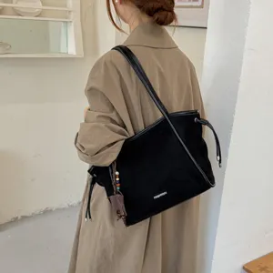 Vue détaillée du sac cabas d'épaule en suédine noire au style vintage pour le quotidien.