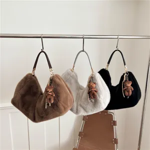 Vista detallada de los elegantes bolsos de hombro de felpa colgando con lindos ositos.