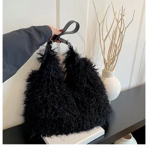 Sac à épaule noir duveteux doté d'une matière pelucheuse et d'une poignée en cuir.