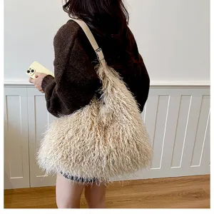 Vue détaillée d'un sac à bandoulière en peluche duveteuse beige avec lanière en cuir, doux.