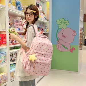 Vue détaillée du joli sac à dos rose étoilé, avec plusieurs compartiments et joli charm.