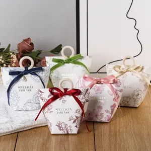 Elegant paper wedding candy gift boxes with wooden ring handles and silk ribbons.