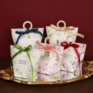 Detailed view of wedding candy gift boxes with wooden ring handles and ribbons on tray.
