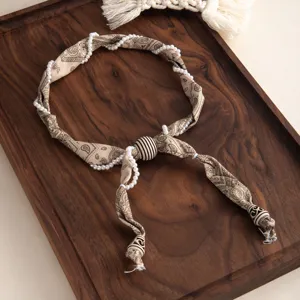 Vue détaillée d'un collier foulard en soie perles paisley rétro, accessoire élégant.