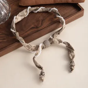 Gros plan détaillé de collier foulard en soie perlé paisley rétro pour femmes élégantes.