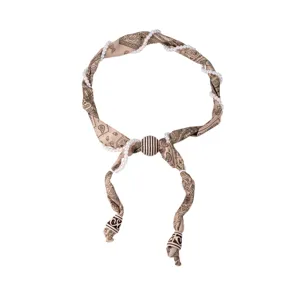Détail du collier foulard en soie paisley rétro entrelacé avec des perles élégantes femmes.