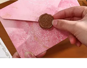 Detail de l'enveloppe texture marbre rose avec beau cachet de cire marron pour lettre vintage.