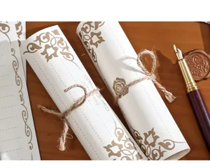 Gros plan détaillé de rouleaux de papier à lettre vintage liés avec ficelle et stylo.
