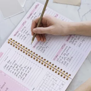 Nahaufnahme Detailansicht des Wochenplaner Notizbuchs mit handschriftlichem Zeitplan.