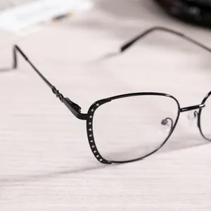 Close-up of black metal anti-blue light glasses with rhinestones, stylish clear lens detail.