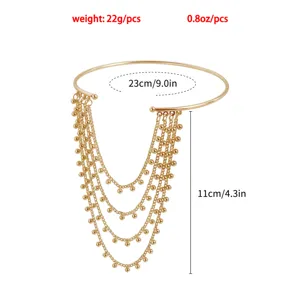 Detailed shot of gold-plated arm cuff featuring multi-layered tassel chains with delicate beads.