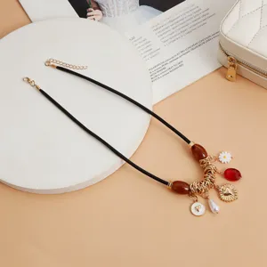 Detailansicht der Vintage-Lederseil-Choker-Halskette mit Charms und Metallringen im Retro-Stil.