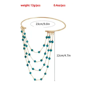 Gold tone arm cuff with multi-layer turquoise bead tassel chains, stylish upper arm jewelry.