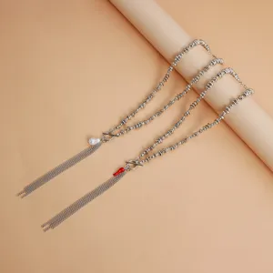Vue détaillée du long collier de perles irrégulières avec glands et pendentif chic.