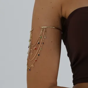 Gold tone multi layer tassel arm cuff with colorful gemstone charms detail close up view