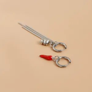 Boucles d'oreilles asymétriques en métal argenté avec chaînes et pendentif piment rouge.
