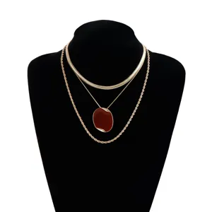 Set di collane stratificate in oro con catena a serpente, ciondolo ovale e catena a corda.