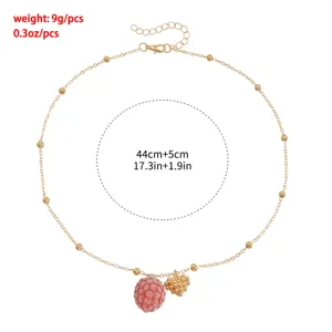Elegant gold chain necklace featuring cute pink raspberry and sparkling heart pendants.