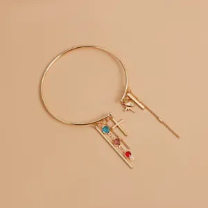 Gold tone arm cuff detail with colorful crystal charms and delicate hanging chains.