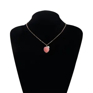 Close-up detail of the pink raspberry pendant necklace with delicate gold chain and pearl.