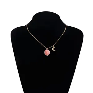 Gold tone clavicle chain necklace featuring a textured pink raspberry and sparkly moon pendant.