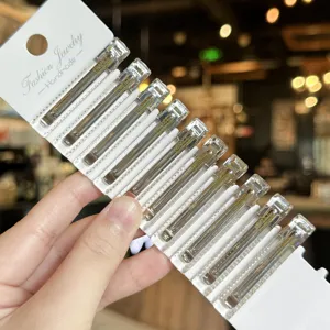Transparent acrylic duckbill hair clip detail view showing clear texture and gold lettering.