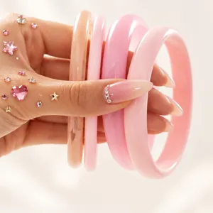 Close-up detail of colorful transparent resin bangles, stylish glossy circular resin bracelets.