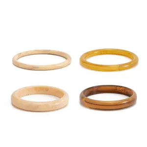 Detailed view of colorful stained transparent resin bracelets, smooth arc bangles in various colors.