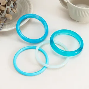 Detail view of colorful resin bangles set, transparent and glossy arc design for fashion daily wear.