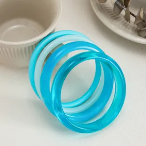 Detailed view of colorful gradient transparent resin bangles, smooth arc design, stylish jewelry.