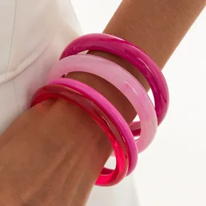 Colorful transparent resin bangles detail shot, fashion glossy stackable wrist bracelets.