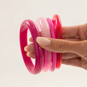 Colorful transparent resin bangle stack, smooth arc design, stylish fashion jewelry detail.