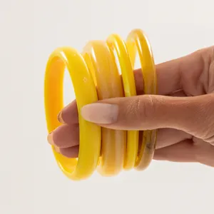 Detailed view of colorful translucent resin bangles, smooth circular stacked fashion jewelry.