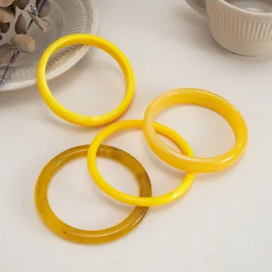 Detail shot of colorful resin bangles, translucent smooth glossy round stackable bracelets.