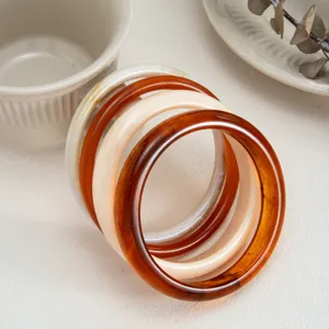 Detail shot of colorful stained transparent resin bracelets featuring smooth arc design.