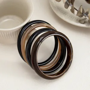 Detailed view of fashionable resin bangles, smooth arc surface, stained translucent colors.