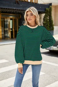 Nahaufnahme des grünen gestreiften Sweatshirts mit geripptem Kragen und Ärmelbündchen im Freien.