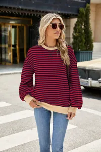Detaillierte Outdoor-Szene mit einem rot-blau gestreiften Damen Langarm Sweatshirt.