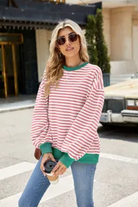 Detailansicht eines stylischen pink-weiß gestreiften Sweatshirts mit grünem Kragen.