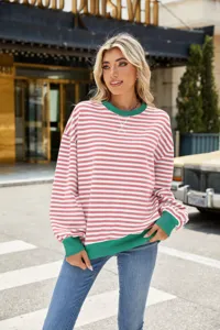 Lässiger rosa-weißer gestreifter Langarm-Pullover mit grünem Saum im Streetstyle Detail.